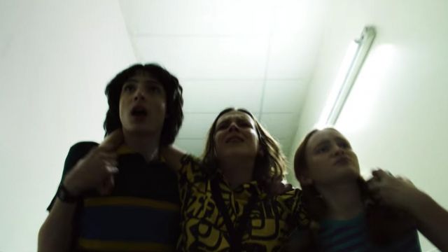 The yellow shirt printed Aztek worn by 11 / Eleven (Millie Bobby Brown) in Stranger Things (S03E08)