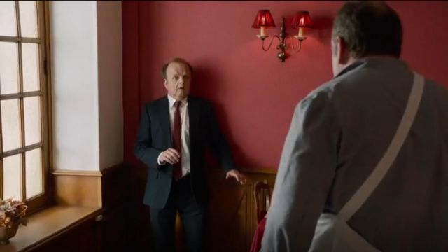 Chaqueta de traje negro de Newman (Toby Jones) en Normandie Nue