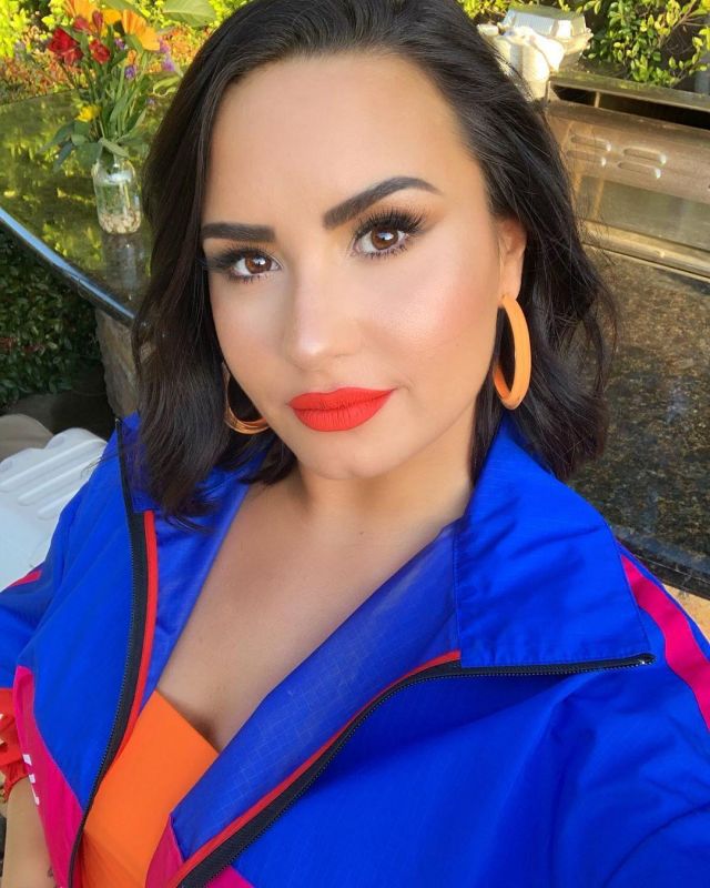 El ajustado mini vestido naranja Meshki de Demi Lovato en su cuenta de Instagram @ddlovato