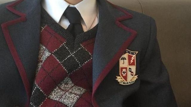 Umbrella Academy School Emblem Uniform Patch porté par Number Five (Aidan Gallagher) dans Umbrella Academy (S01E01)