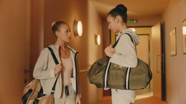 Golden gym bag worn by Lena Grisky (Jessica Lord) in Find Me in Paris (S01E06)