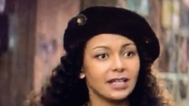 Black beret with flower jewelry worn by hannah lois chimimba in the series The One