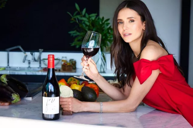 La robe rouge Valentino et le vin rouge goûté par Nina Dobrev sur son compte Instagram @nina