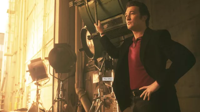 Camisa polo roja con cremallera usada por Albert S. Ruddy (Miles Teller) como se ve en los atuendos de la serie de televisión The Offer (Temporada 1)