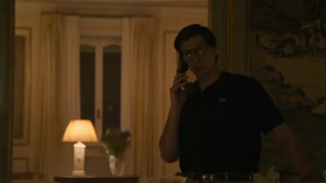 Lacoste black polo shirt worn by Maurizio Gucci (Adam Driver) as seen in House of Gucci outfits