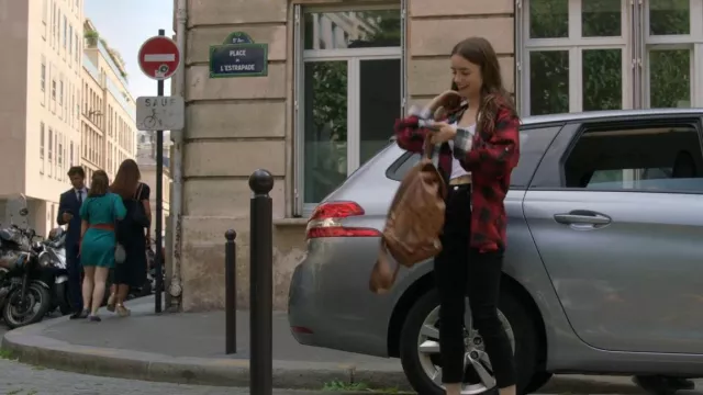 MCN Brown Logo Print Backpack worn by Emily Cooper (Lily Collins) as seen in Emily in Paris TV show wardrobe (Season 1 Episode 1)
