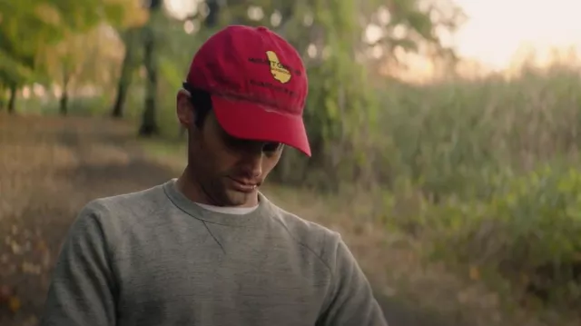 The red Mount Gay Rum cap worn by Joe Goldberg (Penn Badgley) in the series YOU (Season 1 Episode 6)
