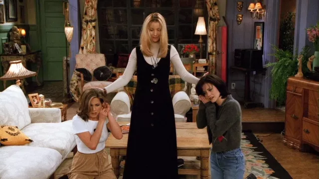 La longue robe noire à boutons portée par Phoebe Buffay (Lisa Kudrow) dans la série Friends (S02E13)