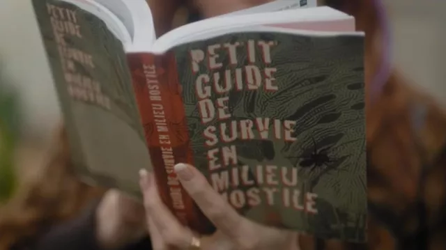 The book little guide to survival in hostile environment potassé by Morgane Alvaro (Audrey Fleurot) in HPI : High Intellectual Potential (S01E03)