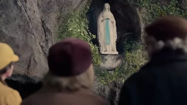 Statue de Notre-Dame de Lourdes dans la grotte de Massabielle à Lourdes, France vue dans The Miracle Club