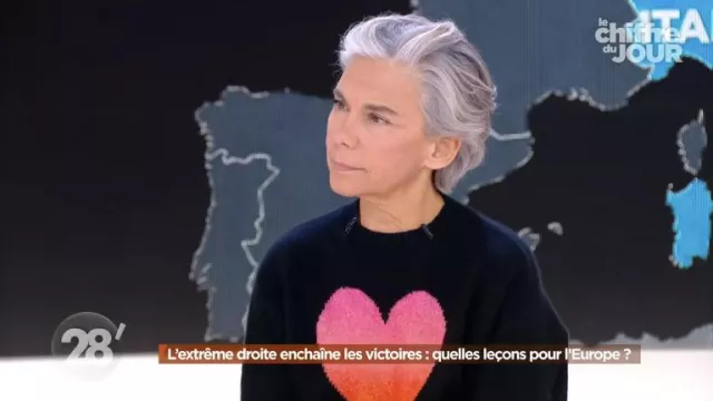 Le pull noir avec un gros coeur en maille porté par Élisabeth Quin dans l'émission 28 minutes du 27 novembre 2023