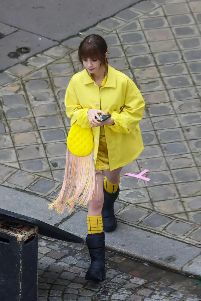 Silvia Tcherassi Fringe Yellow handbag worn by Lily Collins on the set of Emily in Paris on February 16, 2024