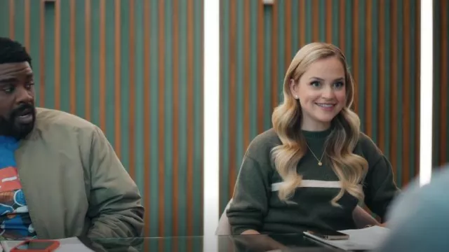 Pull d’hiver en laine vert J.Crew avec rayures beige porté par Ainsley (Stephanie Styles) comme on le voit dans Loot (S02E01)