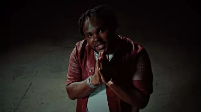 Chemise de baseball en cuir perforé rouge Amiri portée par Tee Grizzley dans Tee Grizzley - Robbery 7 [Vidéo officielle]