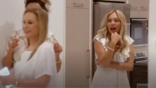 Zimmermann Robe midi blanche sans manches à volants portée par Sutton Stracke comme on le voit dans Les vraies femmes au foyer de Beverly Hills (S14E16)