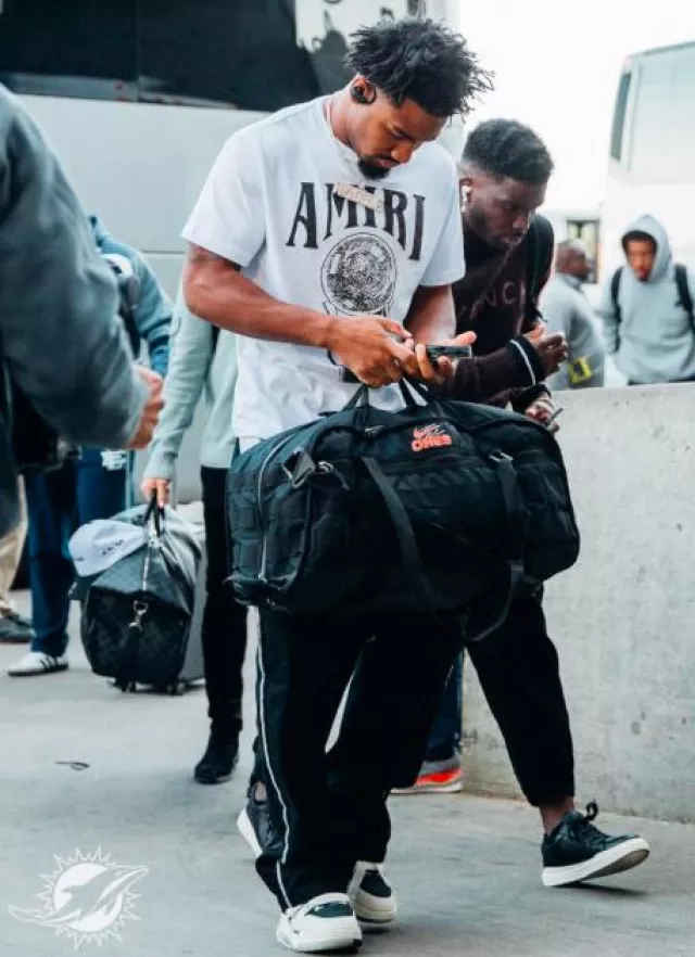 Vaqueros acampanados negros con rayas de cristal de Amiri usados por Jaylen Waddle en la cuenta de Instagram @miamidolphins
