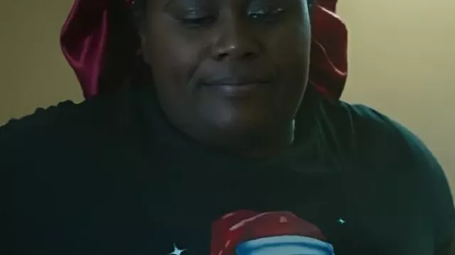 Oh. Quoi. Amusement. T-shirt noir de Noël de Noël porté par Morgan (Danielle Brooks) tel qu’on le voit dans Oh. Quoi. Amusement.