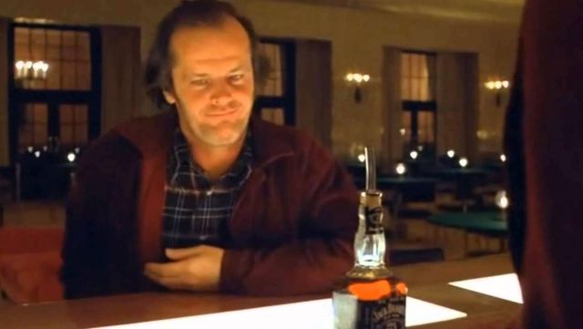 La bouteille de whisky Jack Daniel's devant Jack Torrance (Jack Nicholson) dans Shining