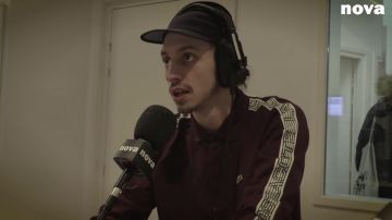 Le polo Lacoste bordeaux de Roméo Elvis dans la vidéo YouTube Roméo Elvis, entretien sans filtre sur Nova