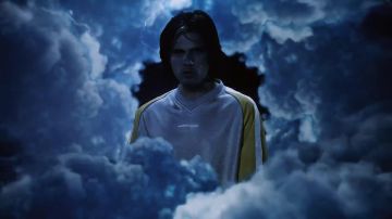 Le pull gris à bandes jaunes de Orelsan dans son clip Rêves bizarres feat. Damso