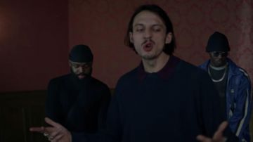 Le polo foncé à col bordeaux porté par Roméo Elvis dans son clip Normal