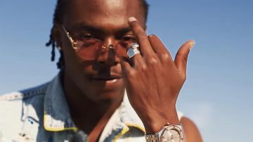 Gafas con montura dorada y lentes rosas de Koba LaD en el clip BINKS de 100 Blaze