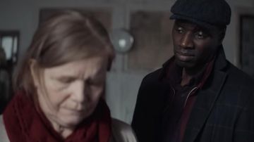 El abrigo azul marino (o negro) con finos cheques de Assane Diop (Omar Sy) en la serie Lupin (S01E04)