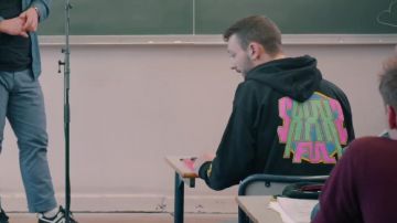 La sudadera con capucha que lleva Roman Frayssinet en el vídeo de YouTube NUESTRAS PEORES ANÉCDOTAS SEXUALES FEAT. LLENO DE AMIGOS (frente a una clase de estudiantes de secundaria)
