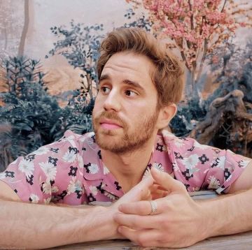 Pink button-up collared shirt with navy blue and flower pattern worn by Ben Platt on the Instagram account of @benplattdefensesquad