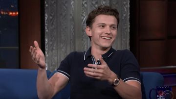 The black polo shirt with white stripes worn by Tom Holland in the show The Late Show with Stephen Colbert