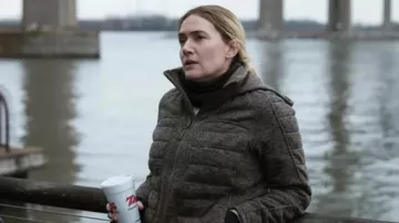 Veste matelassée brune portée par le détective Mare Sheehan (Kate Winslet) telle que vue dans la garde-robe de la série télévisée Mare of Easttown (saison 1 épisode 5)