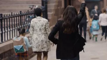 Bolso de cadena negra usado por Rebekah Neumann (Anne Hathaway) en los atuendos de la serie de televisión WeCrashed (Temporada 1 Episodio 4)