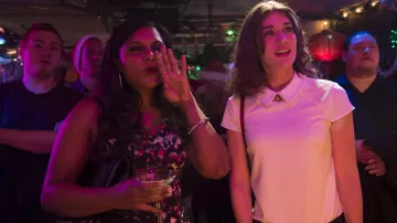 Le polo blanc à col et épaule perlés de Diana (Lizzy Caplan) dans le film The Night Before