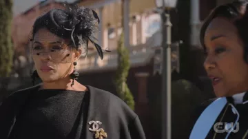 Broche à logo Chanel portée par Lorraine Swift (April Parker Jones) telle que vue dans les tenues de la série télévisée Tom Swift (saison 1 épisode 1)