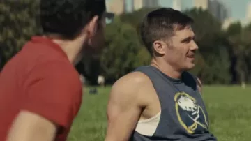 Camiseta sin mangas impresa gris usada por Aaron (Luke Macfarlane) como se ve en la película Bros