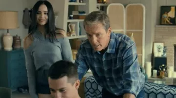 The cream-colored sweater with an open shoulder worn by Cassie (Sofia Carson) in the movie Our Bruised Hearts