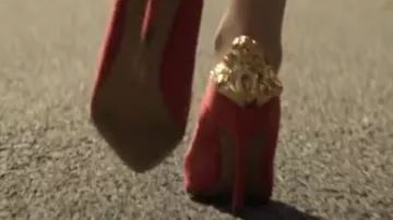 Tacones altos rojos con relieve dorado usado por un personaje como se ve en la serie de televisión The Sandman (S01E09)