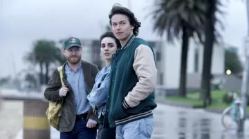 Veste universitaire verte portée par Josh Harris (Jack Martin) telle que vue dans la garde-robe de la série télévisée La Brea (saison 2 épisode 2)