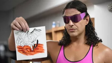 Lunettes à visière rose portées par Bret 'Hitman' Hart (Nicholas Bernardi) dans la garde-robe de la série télévisée Young Rock (saison 3 épisode 1)
