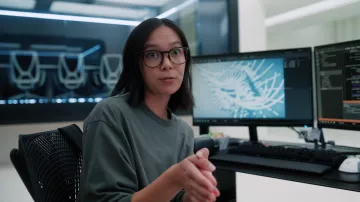 Haut gris à manches longues porté par Poppy (Charlotte Nicdao) dans les tenues de la série télévisée Mythic Quest (S03E02)