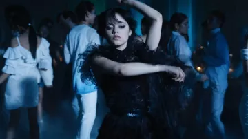 La robe noire à pois avec collerette en tulle portée par Wednesday Addams (Jenna Ortega) dans la série Mercredi (Saison 1 Épisode 4)