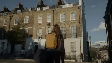 Sac à dos jaune moutarde porté par Lucy Carlyle (Ruby Stokes) comme on le voit dans la série télévisée Lockwood & Co. (saison 1)
