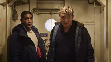 Manteau bleu marine porté par le Dr Sigur Johanson (Alexander Karim) comme on le voit dans The Swarm (saison 1)