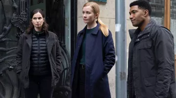 Gabardina azul marino usada por la agente de Europol Megan 'Smitty' Garretson (Eva Jane Willis) como se ve en FBI: International (S02E15)