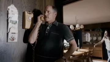 Polo noir porté par E. Howard Hunt (Woody Harrelson) vu dans White House Plumbers (saison 1)