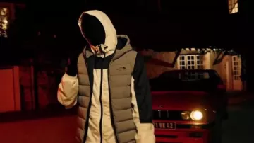 La doudoune sans manche The North Face avec capuche portée par menace Santana dans son clip Guapman