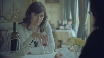 Chemisier blanc porté par Elsa Lombardi (Emily Mortimer) dans The New Look (saison 1)