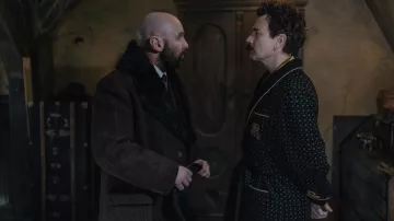 Manteau à carreaux avec col en fourrure porté par Ossip Glebnikov (Johnny Harris) comme on le voit dans Un gentleman à Moscou (saison 1)