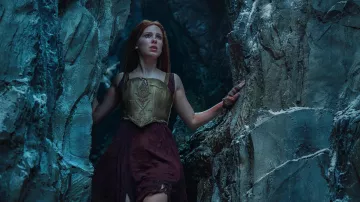 Haut corset doré porté par Elodie (Millie Bobby Brown) comme on le voit dans les tenues de film de Demoiselle