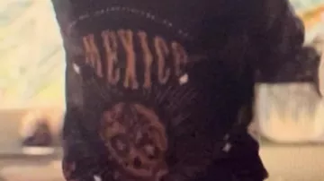 Chemise porté par (Hélène Theunissen) dans Attraction (S01E01). Vers la 40ème minute par la mère de l’actrice principale. Noire et beige ou dorée avec inscription mexico dans le dos et tête de mort et differents motif mexicain devant et derrière.